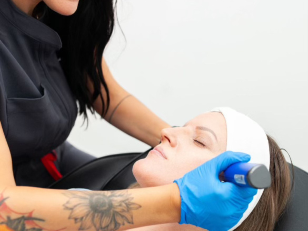 Nurse using a skin pen to perform microneedling on client